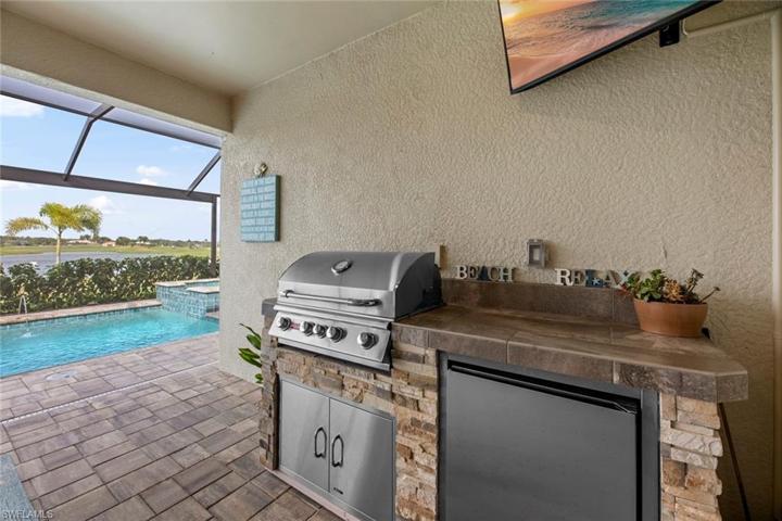 New outdoor kitchen with grill, refrigerator and mounted TV (June 2023)