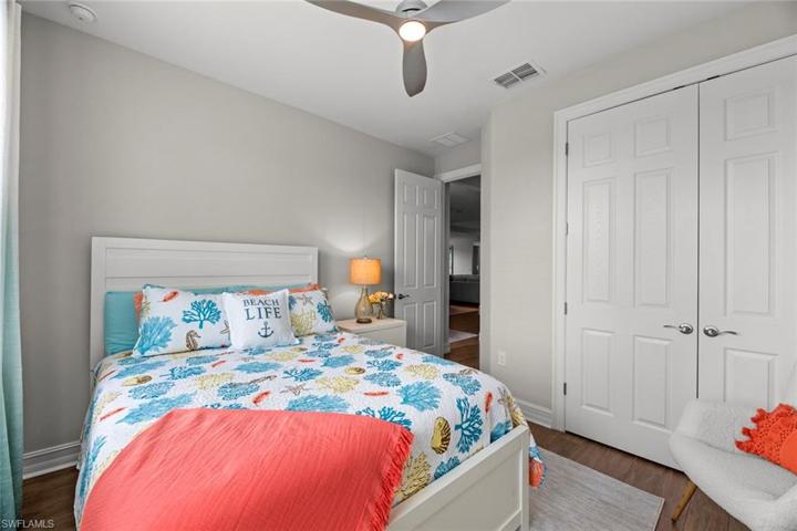 Bedroom 4 with new WOOD-LOOK TILE FLOOR (October 2022), new ceiling fan/ight (October 2022), and window blinds.