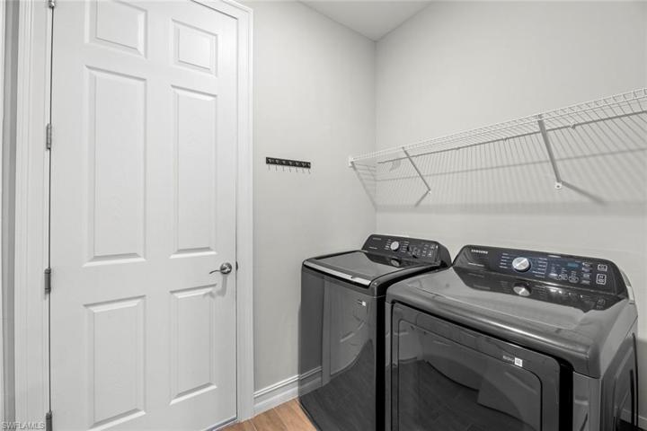 Laundry room with WOOD-LOOK TILE FLOOR, WASHER, and DRYER.