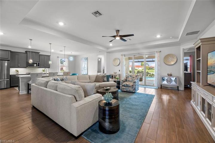WOOD-LOOK TILE extends throughout the home. Upgrades include tray ceiling, recessed lighting, WATER/GOLF COURSE VIEW, and sliders leading out to the new extended screened lanai and pool area. New ceiling fan/light (October 2022)