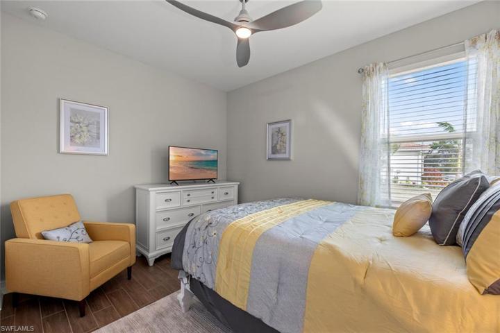 Bedroom 3 with new WOOD-LOOK TILE FLOOR (October 2022), new ceiling fan/ight (October 2022), and window blinds.