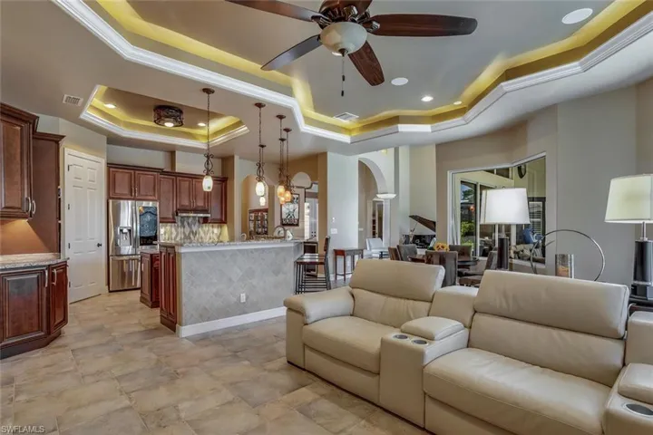 Tiled floor, recessed lighting, coffer lighted ceiling with crown molding, ceiling fan