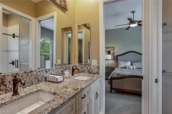 Shared bathroom featuring double vanity, separate walk-in and tiled shower, w.c.