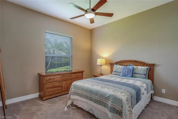 Carpeted bedroom featuring ceiling fan