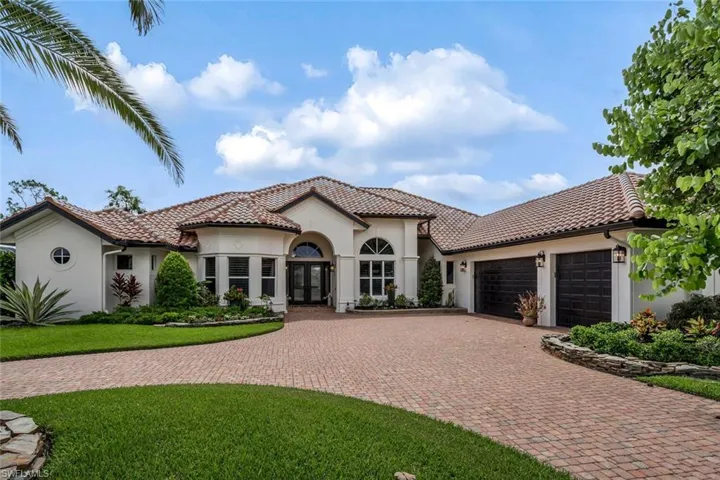 Mediterranean / Spanish-style home featuring a 3 car garage with large circle drive
