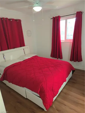 Bedroom with dark wood finished floors and a ceiling fan