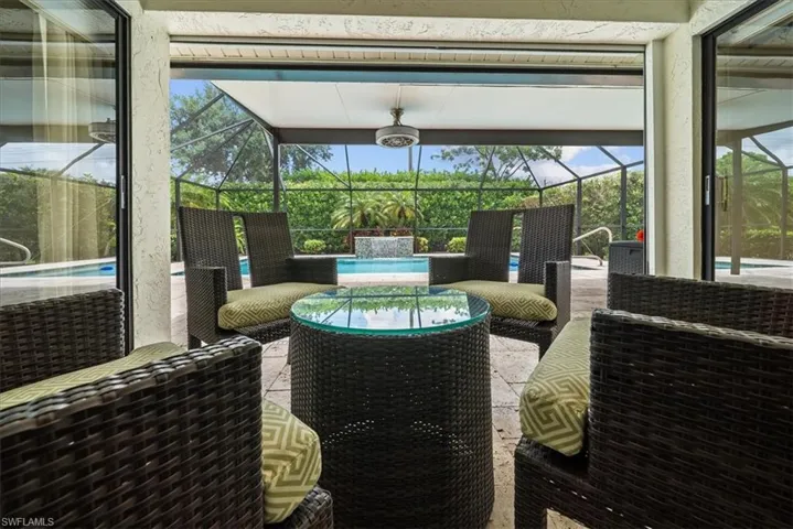 View of patio featuring glass enclosure, an outdoor pool, and an outdoor hangout area