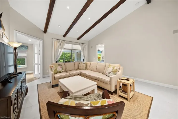 Living area featuring beam ceiling, high vaulted ceiling, and recessed lighting