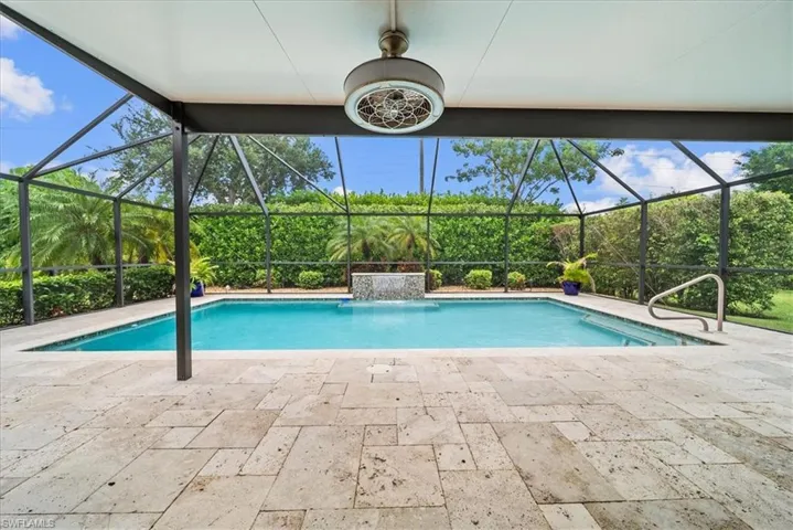 Swimming pool featuring glass enclosure and a patio area