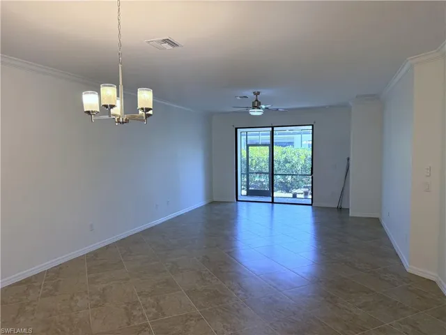 Spare room with a ceiling fan, ornamental molding, and a chandelier