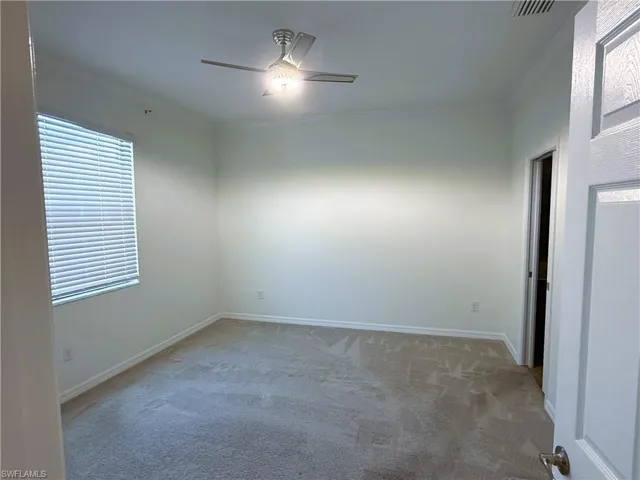 Spare room with light colored carpet, a ceiling fan, and crown molding