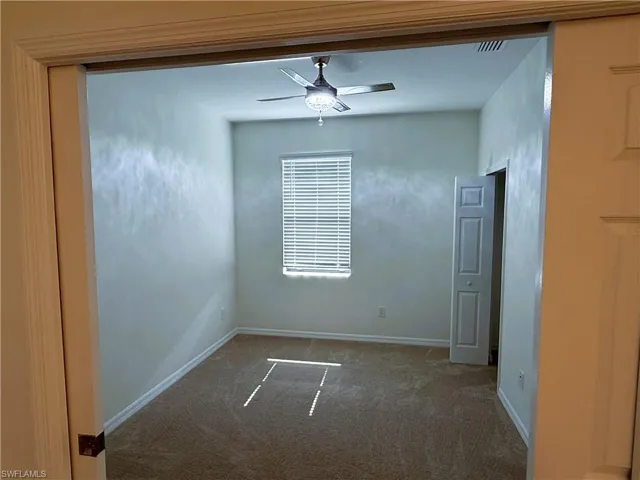 Unfurnished room with a ceiling fan and carpet flooring