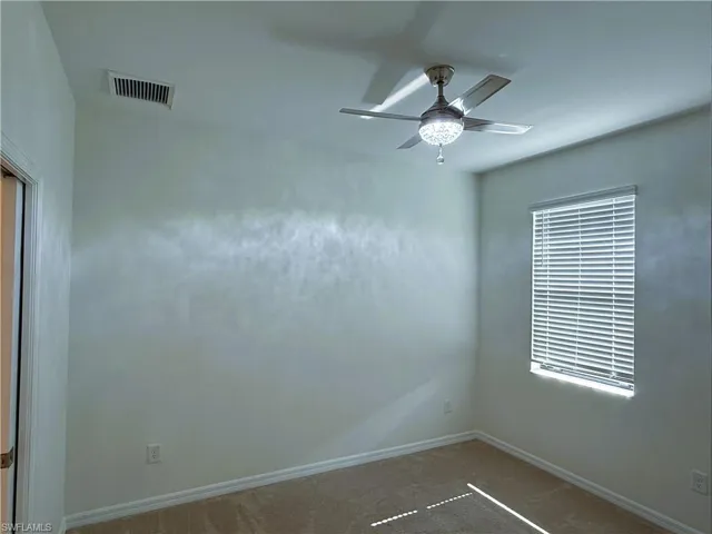 Unfurnished room with a ceiling fan and carpet floors