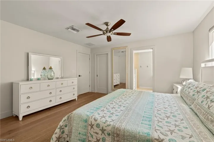 Bedroom with visible vents, ceiling fan, and wood finished floors