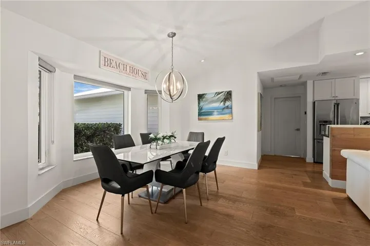 Dining space featuring visible vents, an inviting chandelier, hardwood / wood-style flooring, and baseboards