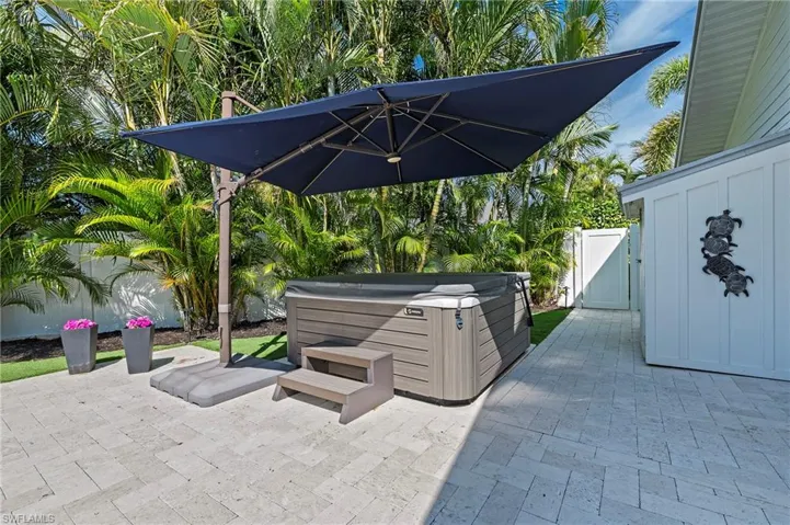 View of patio / terrace with a gate, a fenced backyard, and a hot tub
