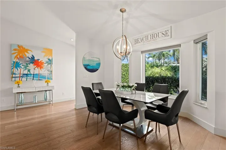 Dining room with a notable chandelier, hardwood / wood-style flooring, and baseboards