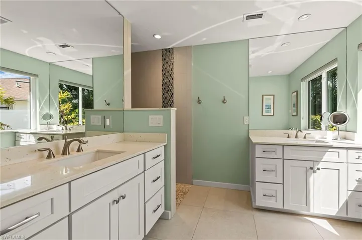 Bathroom with two vanities, a sink, visible vents, and tile patterned floors