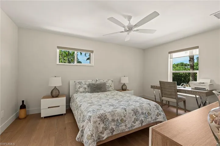 Bedroom featuring a ceiling fan, baseboards, and wood finished floors