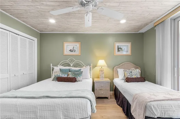 Bedroom featuring light wood-style floors, a closet, a ceiling fan, and recessed lighting - Virtually Edited Image