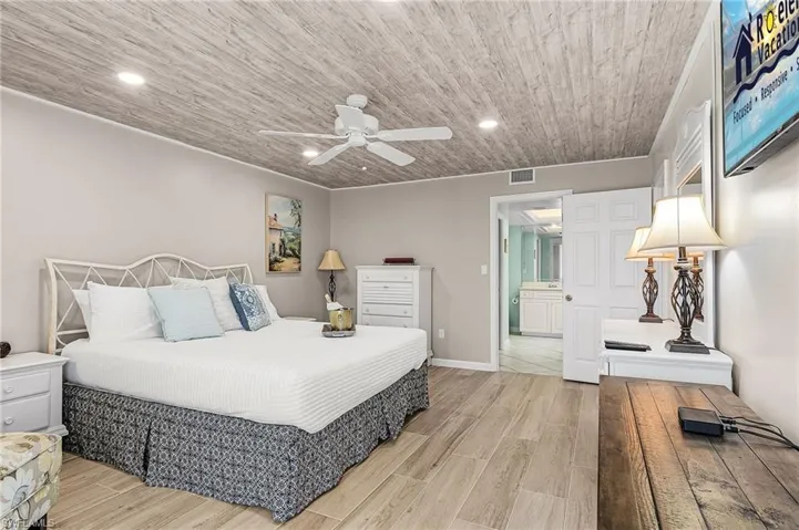 Bedroom with wood tiled floors, wood ceiling, a ceiling fan, and recessed lighting - Virtually Edited Image