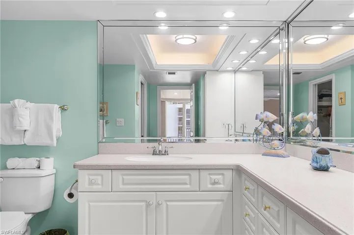 Bathroom featuring vanity, recessed lighting, a raised ceiling, and crown molding - Virtually Edited Image