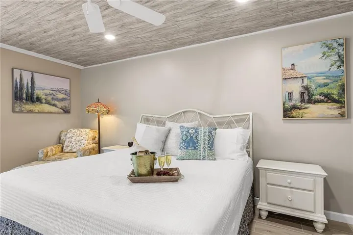 Bedroom with wood finish floors and a ceiling fan - Virtually Edited Image