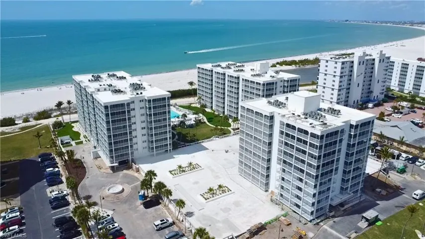 Aerial view of apartment complex and expansive beach - Virtually Edited Image
