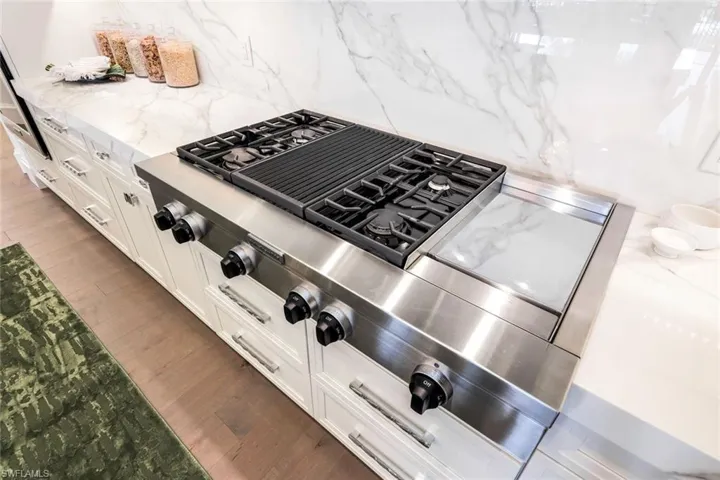 Four burner range with grill feature and griddle
