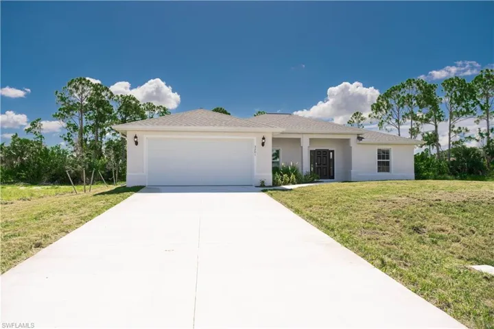 View of front of property with a garage and a front yard