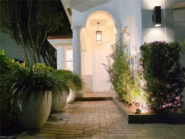 Exterior entry at twilight with stucco siding