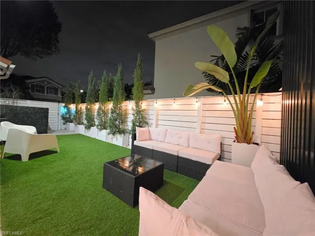 Yard at twilight with a fenced backyard, an outdoor living space, and a patio area