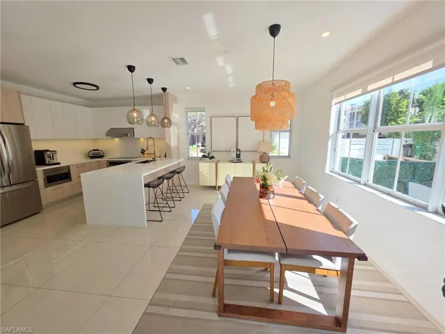 Dining area with light tile patterned flooring and recessed lighting
