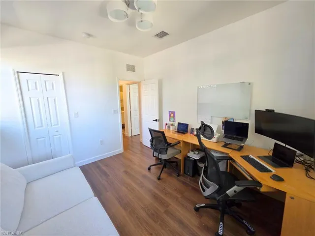 Office with dark wood-type flooring and baseboards