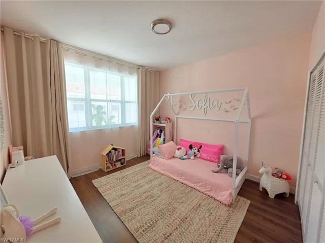 Bedroom featuring dark wood finished floors and a closet