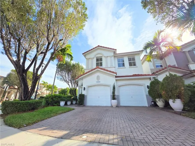 Mediterranean / spanish-style home featuring decorative driveway, a tiled roof, stucco siding, and an attached garage