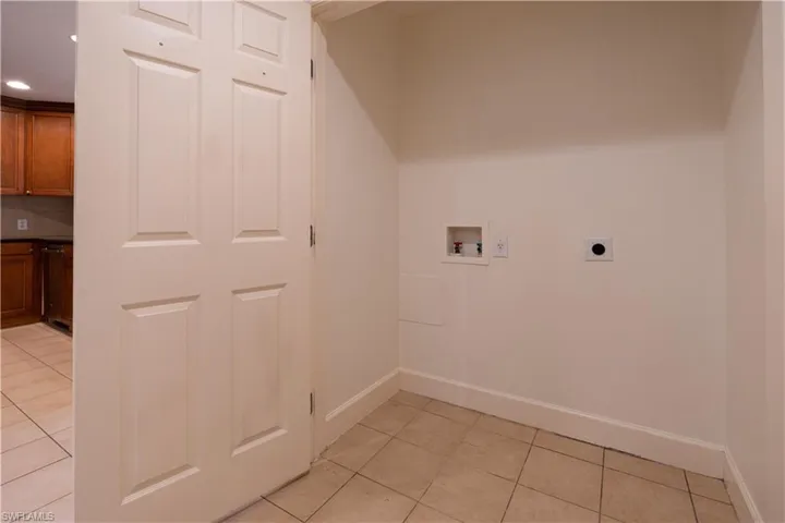 Washroom featuring hookup for an electric dryer, hookup for a washing machine, and light tile floors
