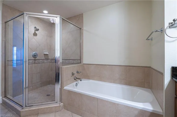 Bathroom with tile flooring and plus walk in shower