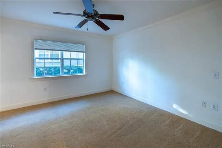 Spare room featuring ornamental molding, carpet floors, and ceiling fan