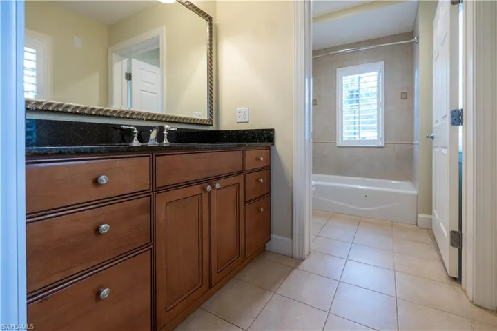 Bathroom with tile floors, tiled shower / bath, and oversized vanity