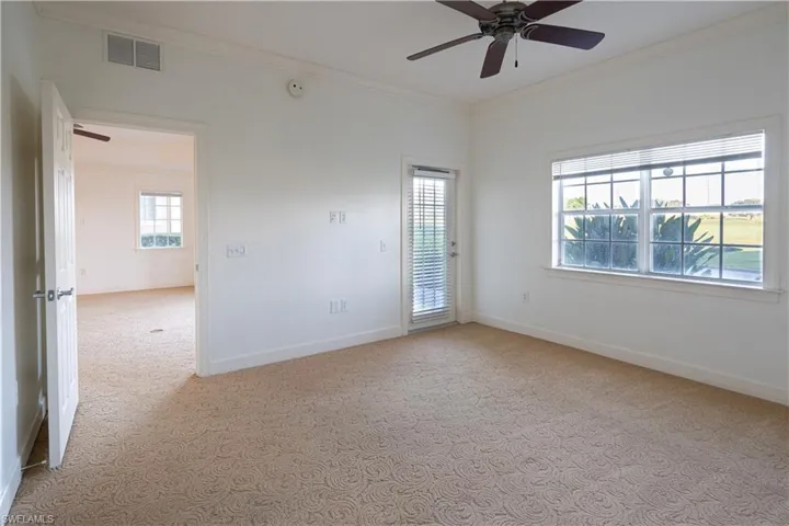 Unfurnished room with crown molding, carpet flooring, and ceiling fan