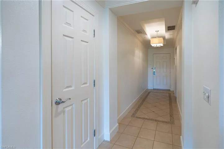 Hall featuring crown molding and light tile floors