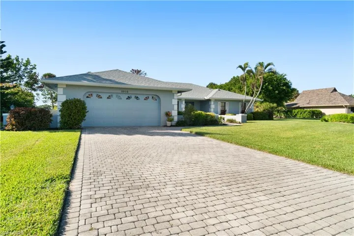Single story home featuring a garage and a front lawn