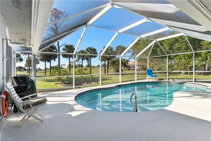 View of pool featuring a lawn, a patio, and a lanai