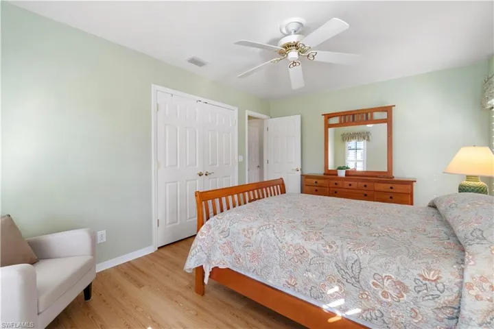 Bedroom with ceiling fan, light wood-type flooring, and a closet