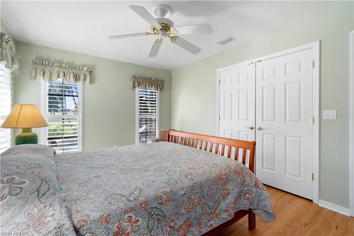 Bedroom with ceiling fan, light wood-type flooring, and a closet