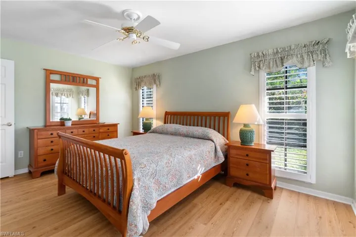 Bedroom with multiple windows, ceiling fan, and light hardwood / wood-style flooring