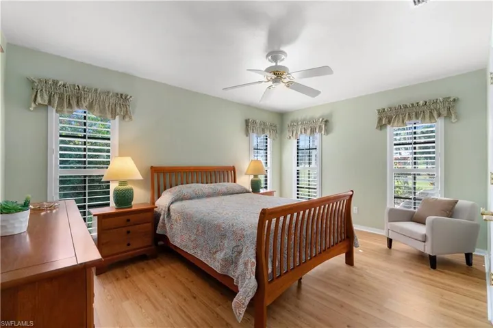 Bedroom featuring light hardwood / wood-style flooring, multiple windows, and ceiling fan