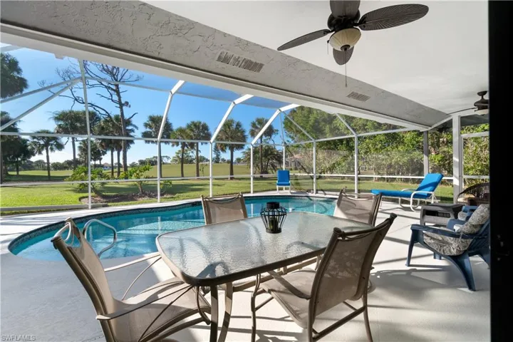 View of pool with a lanai, ceiling fan, a lawn, and a patio