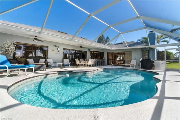 View of pool featuring ceiling fan, an outdoor hangout area, a patio, and glass enclosure